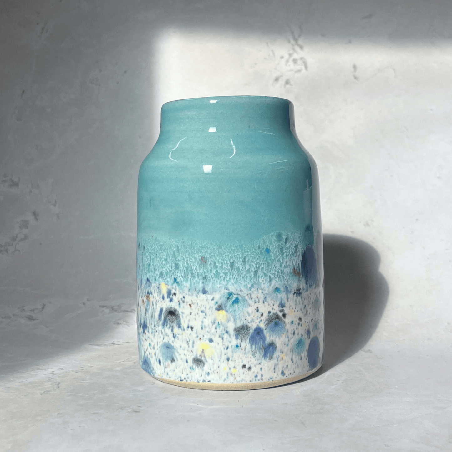 Ella Fletcher Designs Handmade Ceramic Vase in Pale Blue Shoreline Design - vase with solid blue top and multi-coloured speckles at the bottom