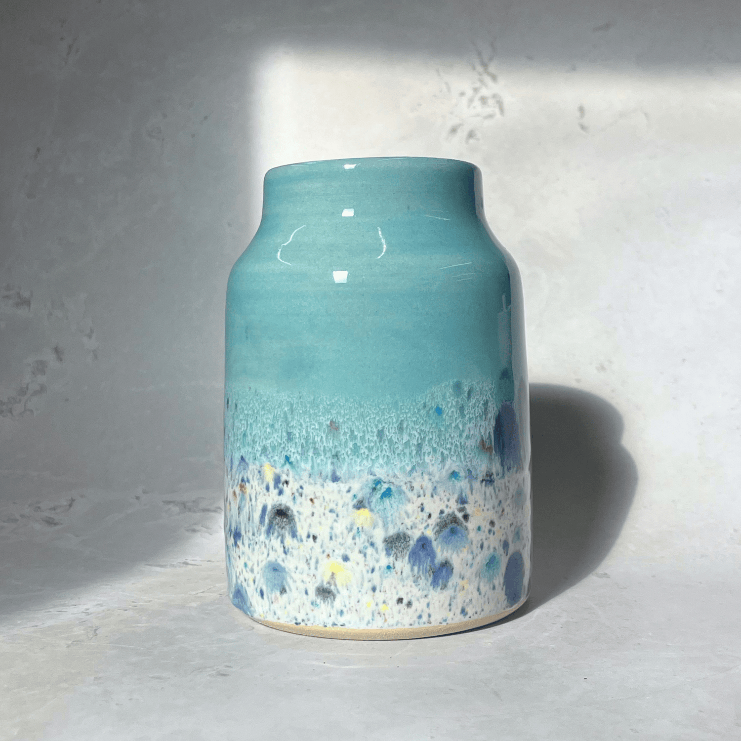 Ella Fletcher Designs Handmade Ceramic Vase in Pale Blue Shoreline Design - vase with solid blue top and multi-coloured speckles at the bottom
