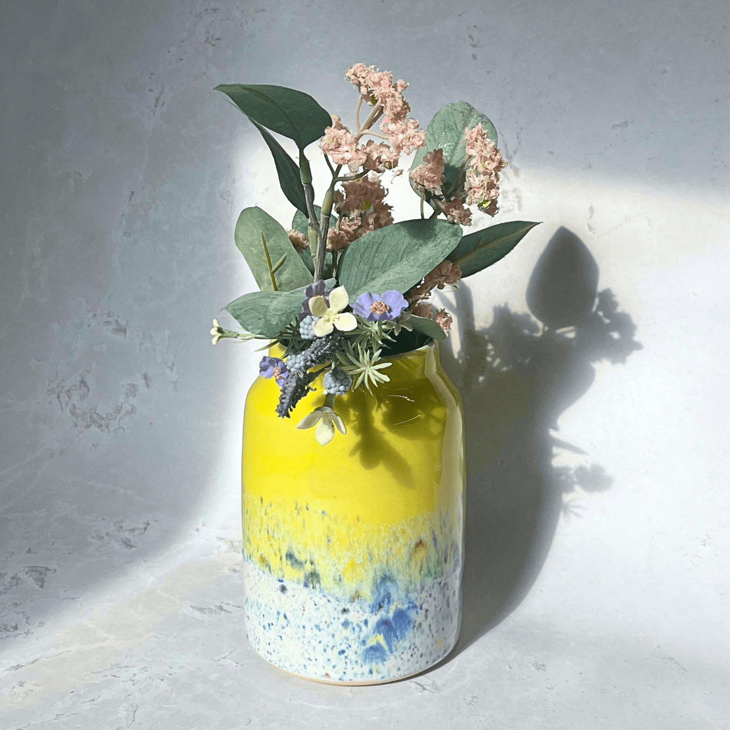 Ella Fletcher Designs Handmade Pottery Vase in Yellow Shoreline Design - vase with solid yellow top and multi-coloured speckles at the bottom featuring flowers
