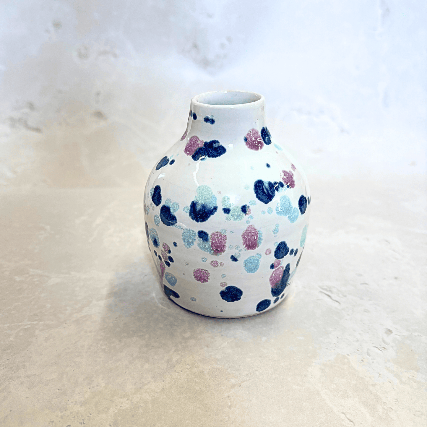 Ella Fletcher Designs Handmade UK Ceramics bud vase in Sweetpea design, small vase with white background and splatters of blues and pinks
