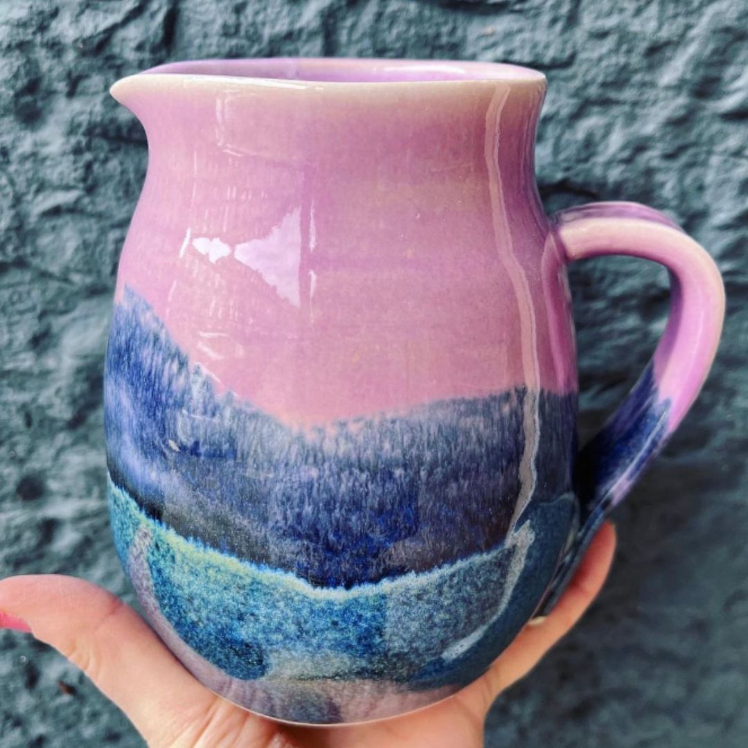 Ella Fletcher Designs Handmade Ceramic Jug in Pink Landscape design, jug with layers of pinks and blues against a blue background
