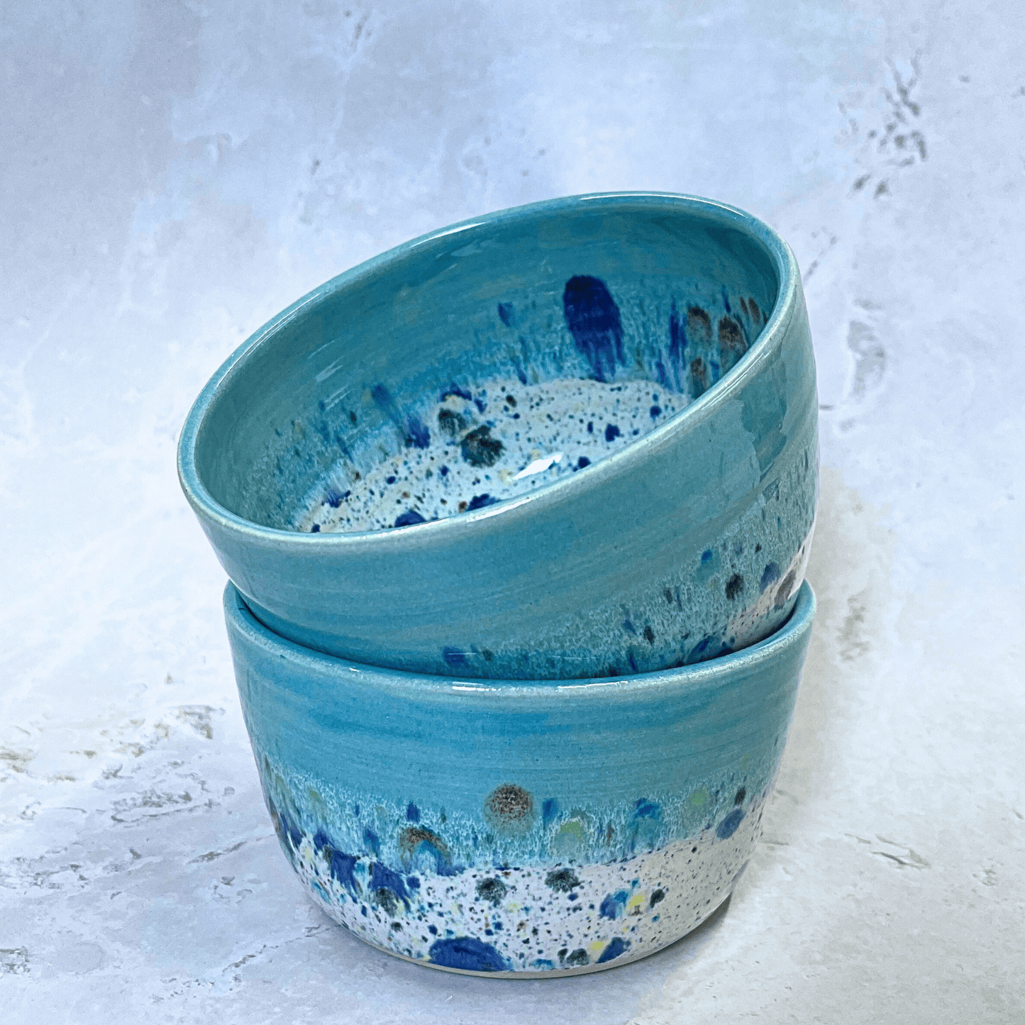Ella Fletcher Designs Handmade Ceramic Small Bowls in Blue Shoreline design, two round bowls with pale blue and multicolour speckles stacked
