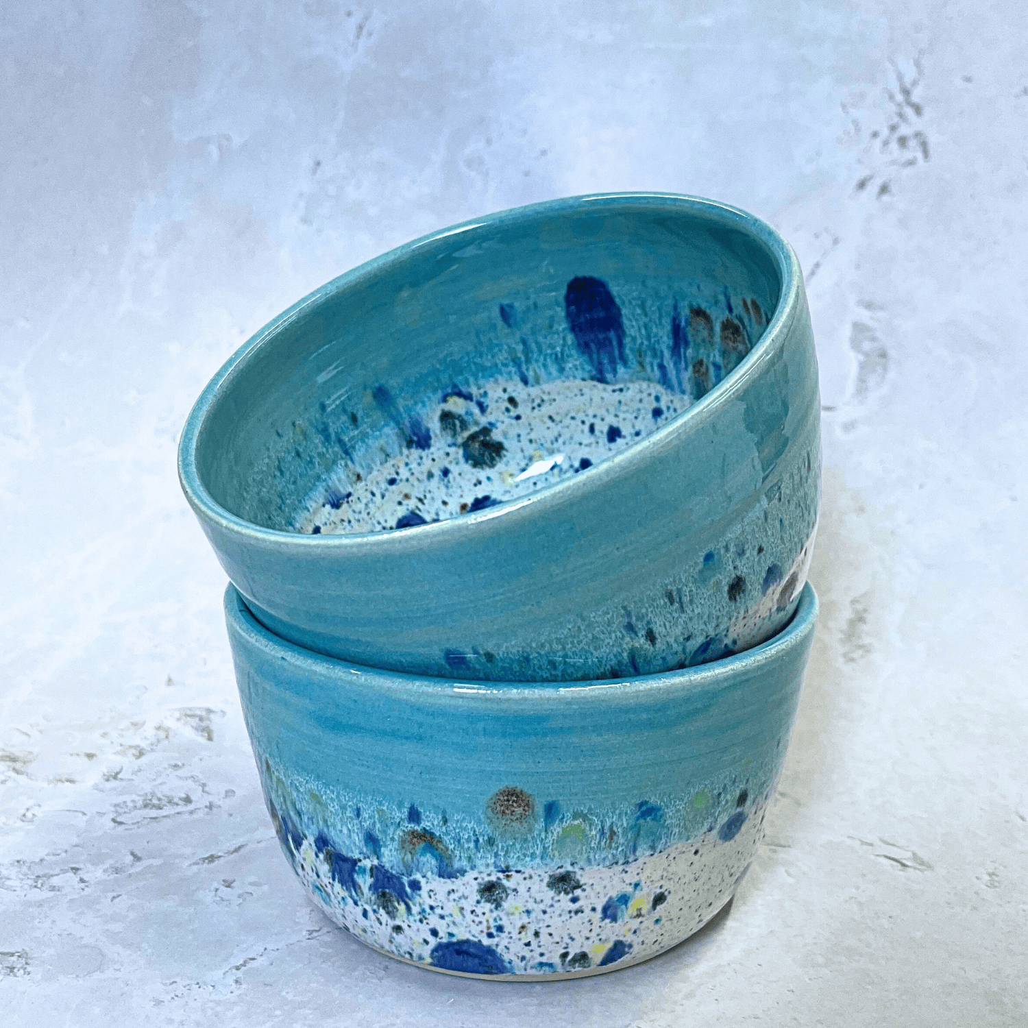 Ella Fletcher Designs Handmade Ceramic Small Bowls in Blue Shoreline design, two round bowls with pale blue and multicolour speckles stacked