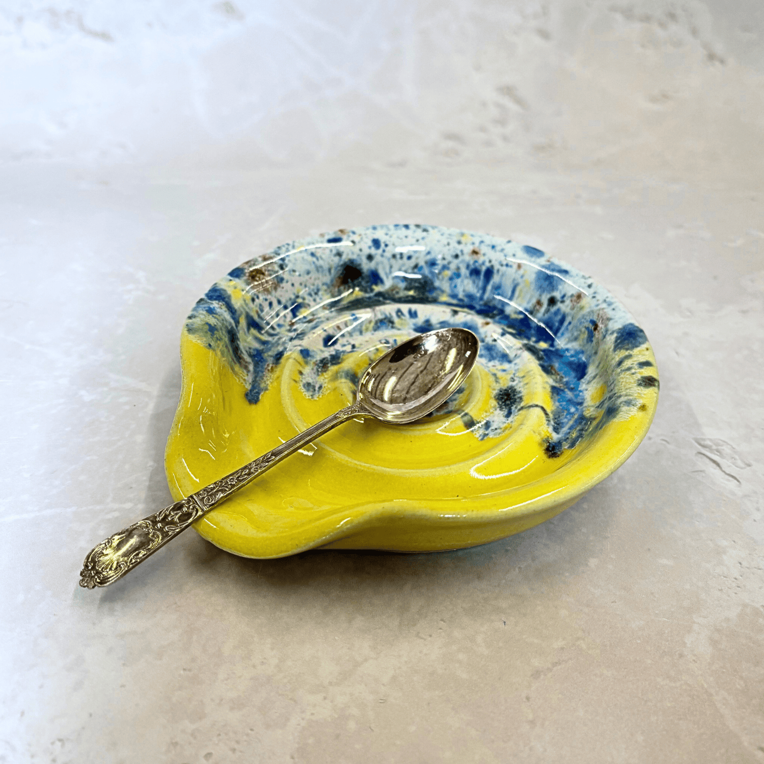 Ella Fletcher Designs Handmade UK Ceramic Spoon Rest in Yellow Shoreline design - yellow and multicoloured speckles on a circular ridged spoon rest
