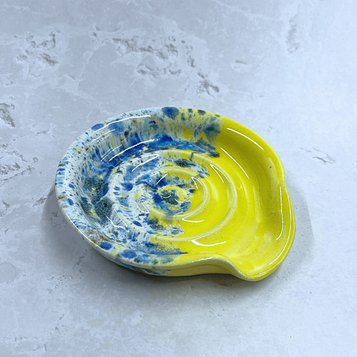 Ella Fletcher Designs Handmade UK Ceramic Spoon Rest in Yellow Shoreline design - yellow and multicoloured speckles on a circular ridged spoon rest