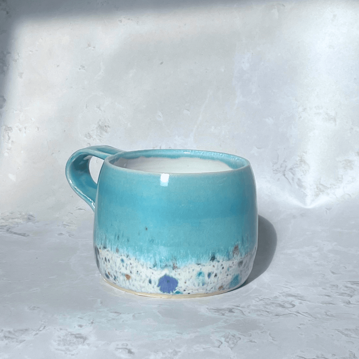 Ella Fletcher Designs Handmade Ceramics Large Round Mug in Pale Blue Shoreline Design, solid blue with speckled multicolour design on a round handmade mug