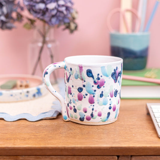 Colorful patterned mug on a wooden surface with a blurred background