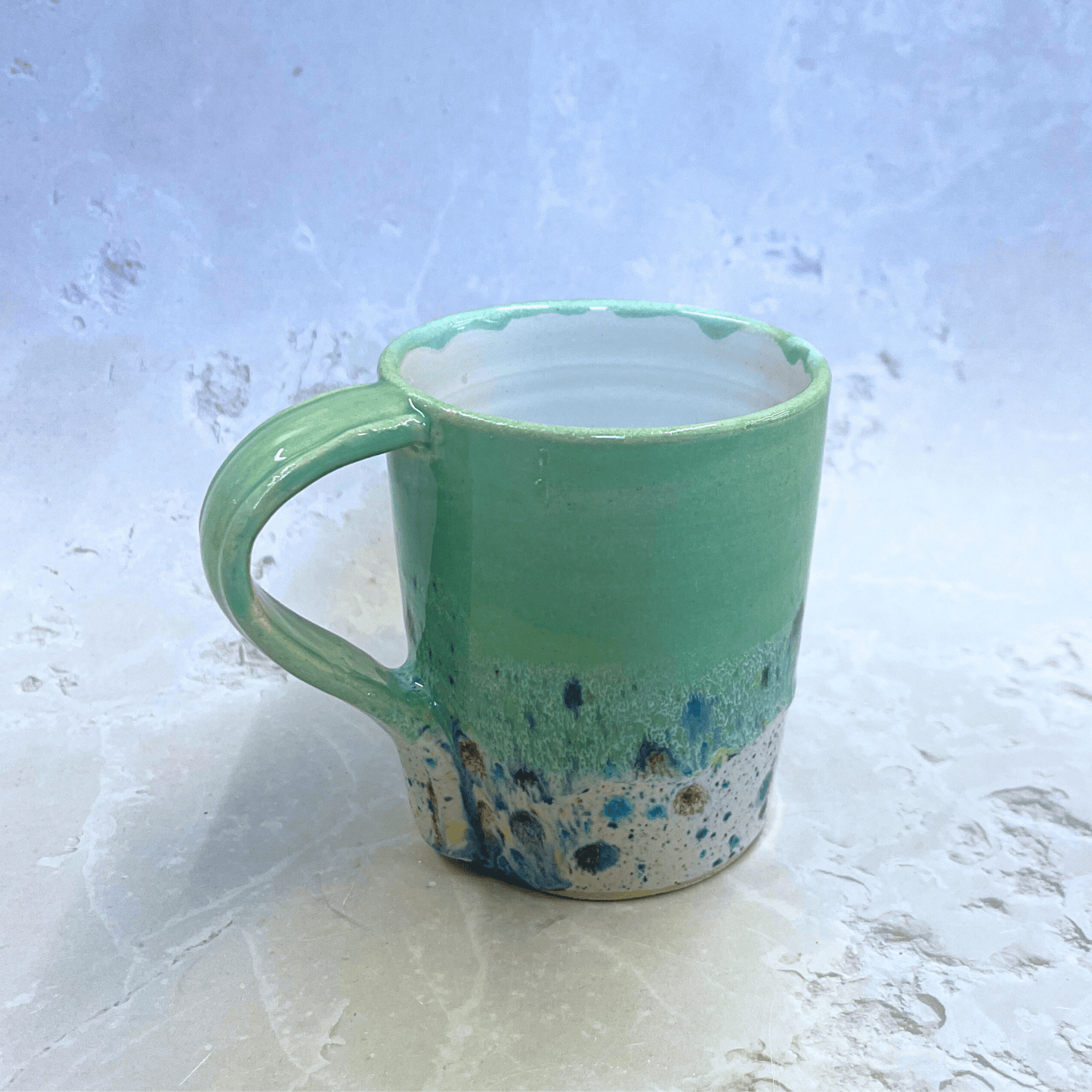 Ella Fletcher Designs Ceramic Mug in Pale Green Shoreline Design, handmade mug with pale green top half with speckled bottom half inspired by the shoreline of East Lothian beaches