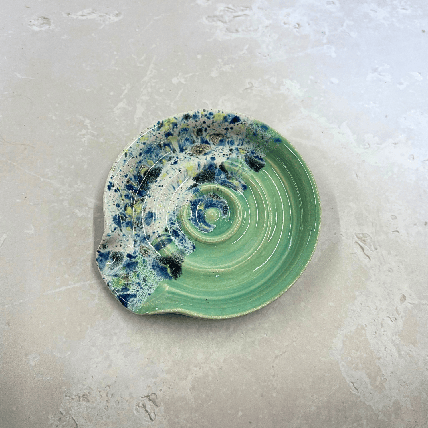 Ella Fletcher Designs Handmade Ceramics Spoon Rest in Green Shoreline, circular spoon rest with ridges, green and multi-coloured speckles